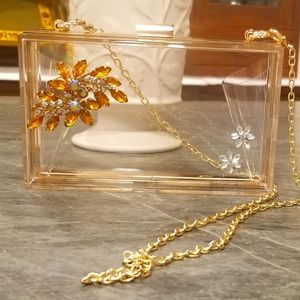 Clear clutch embellished with  vintage jewelry